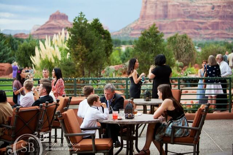 Guests mingling on the patio at Sedona Golf Resort, enjoying the stunning natural scenery in the background.