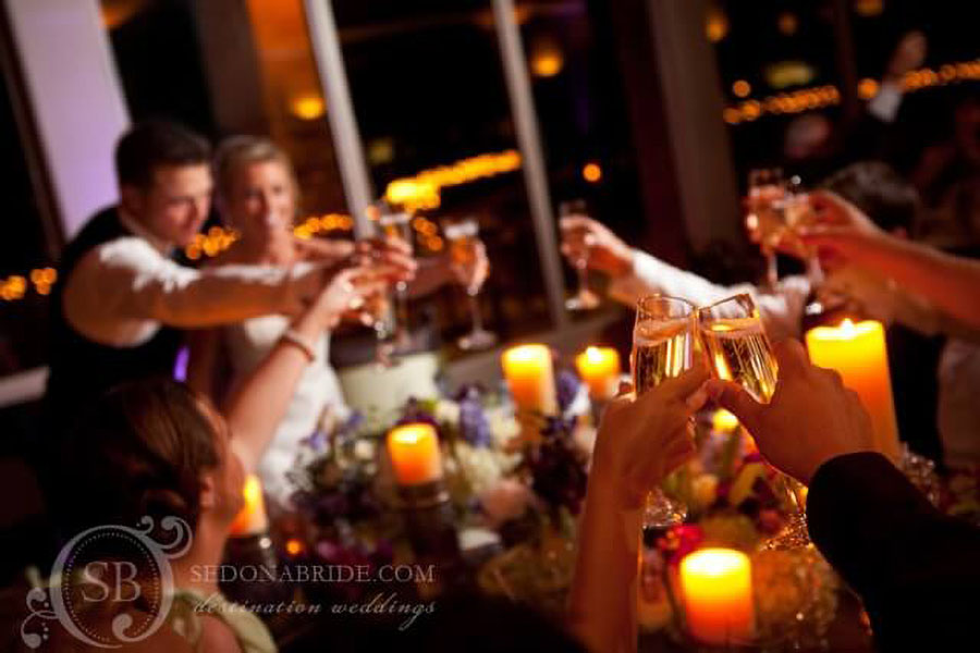 Newlyweds at Sedona Golf Resort toasting with champagne surrounded by joyful guests, celebrating their union.